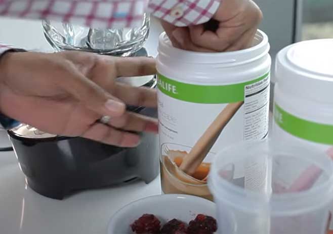 Put 1 Scoop Of Herbalife Formula 1 Wild Berry Flavor: Take the wild berry flavor and put 1 scoop of it into the blender.