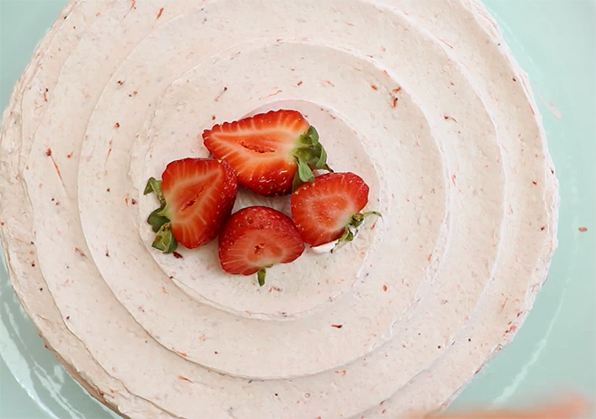 Decorate with fresh strawberries: Now, you can frost cake’s outside with the leftover buttercream and decorate with half-cut strawberries. 