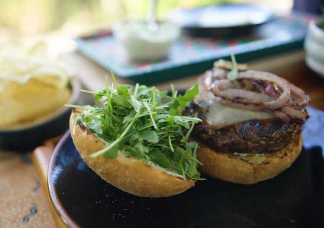 Place Grilled Lamb Patty and Arugula on the Bun