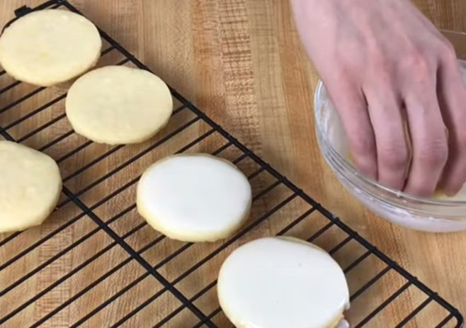 Dip the top of the cookie into the lemon icing