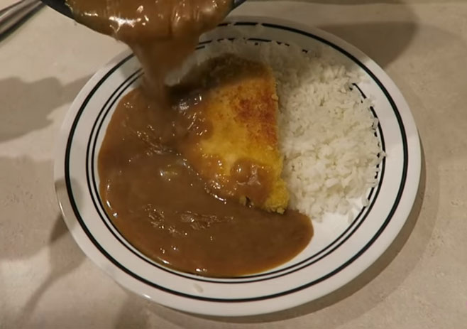 plating the curry with rice and chicken