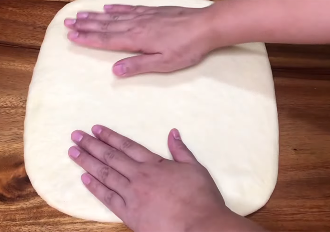 Uncover and flatten the dough