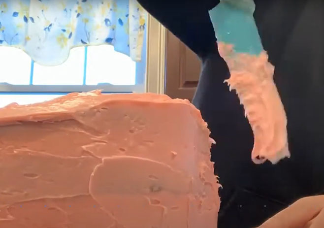 Place pink frosting to cover the cake