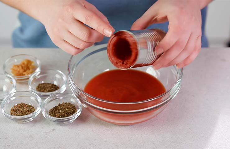 Adding-tomato-paste-and-sauce-in-a-bowl